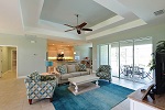 Great room features a tray ceiling and pocket sliders to lanai