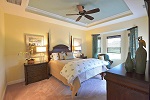 Master bedroom in soothing colors featuring a tray ceiling