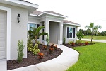 Front entry with sweeping sidewalk and Florida friendly landscaping