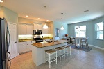 Kitchen with stainless appliances, white cabinets, and granite tops