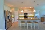 Kitchen with gathering island and designer pendant lights